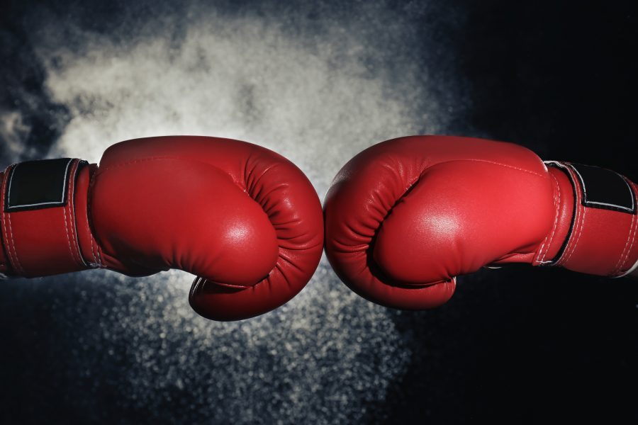 Men in boxing gloves on black background